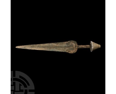 Late 2nd millennium B.C. With solid cast hilt with penannular guard and a horizontally ribbed grip; a conical stone mushroom 