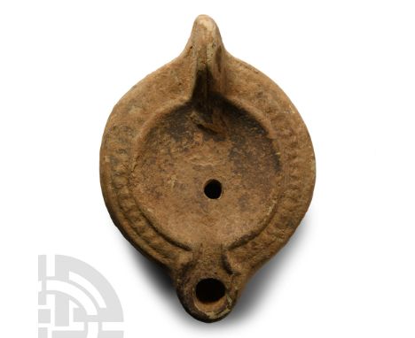 4th century A.D. Gusseted lug handle to rear, discus with filling hole and plain central panel, radiating ribbed border to th