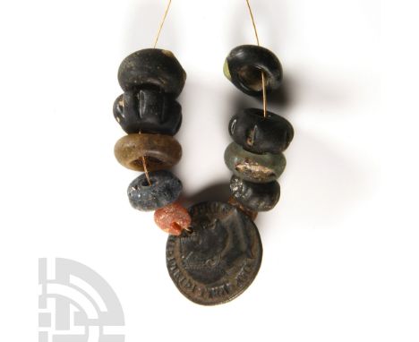 6th-8th century A.D. Restrung, comprising melon and biconvex types and a pierced Roman bronze coin used as a pendant.  14 gra