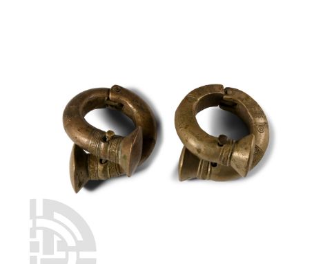 19th century A.D. Pair of hinged bracelets with bell-shaped ends, punched, pointillé and other detailing; pierced to accept a