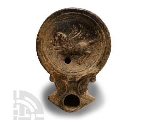 1st century A.D. Squat lamp with broad body and volutes flanking the nozzle, recessed discus with low-relief image of winged 