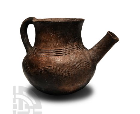 Bronze Age, 2300-1650 B.C. With rounded bottom, broad body and neck, slightly flared rim, strap handle to the rear, spout wit