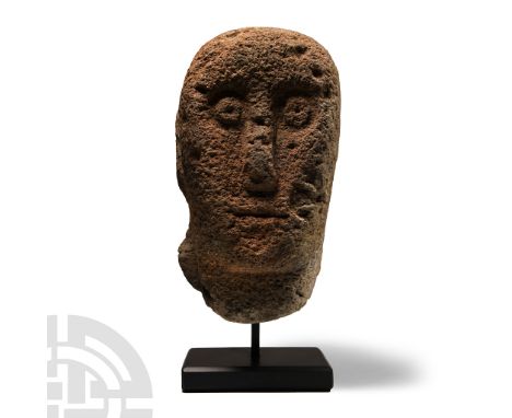 2nd century B.C.-1st century A.D. or later. Sub-rectangular carved head with mount to the rear, elongated facial features, re