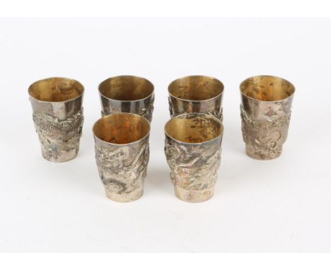 Six Chinese silver shot cups with moulded dragon decoration, mark to bases, 6.4oz, 200g,
