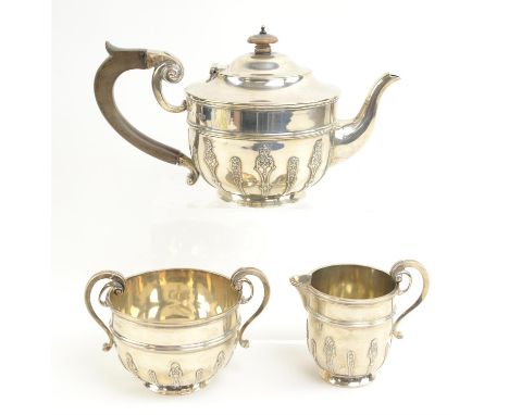 George V silver three piece tea service by Holland with applied decoration, Aldwinckle & Slater, London 1919, gross weight 43