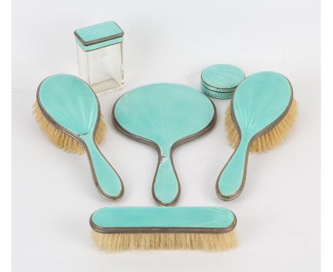 Engine turned and enamelled silver dressing table set in turquoise, comprising hand mirror, two hair brushes, another brush a