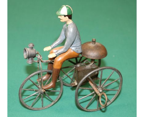 A rare French mid 1800's clockwork tricycle. A simple metal framed bike with metal spoked wheels, clockwork action and bell m