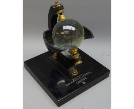 Campbell-Stokes Sunshine Recorder by Negretti and Zambra, model No.8038, with glass sphere on black japanned base, W23cm, H28