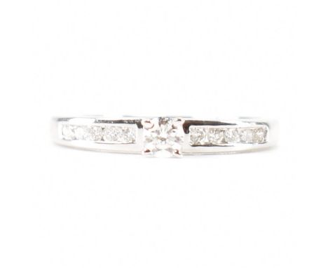 A hallmarked 9ct white gold diamond solitaire ring. The ring set with a round brilliant cut diamond to suspension set diamond
