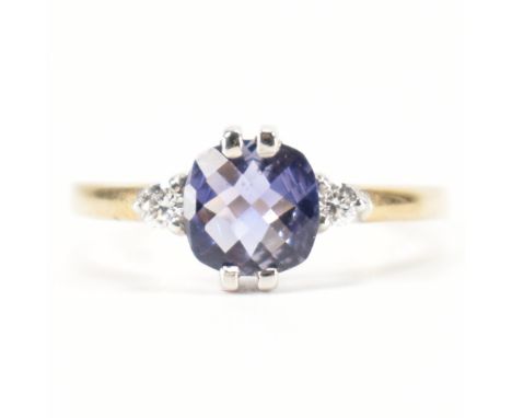 A hallmarked 9ct gold iolite and diamond ring. The ring set with a central cushion chequered cut iolite 6mm x 6mm x 3mm flank