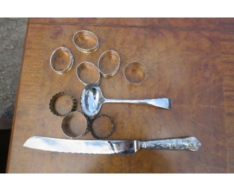 A collection of hallmarked silver to include a ladle, kings pattern handled bread knife, a set of four napkin rings and four 