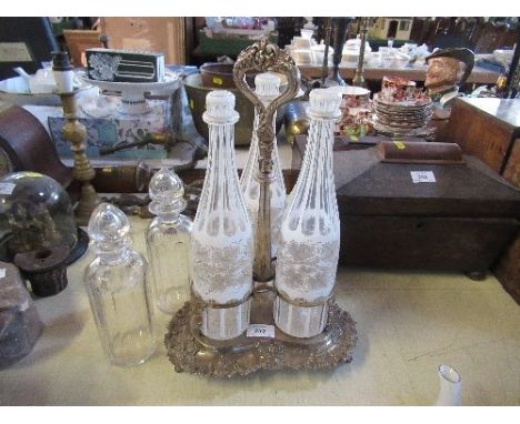 A silver plated decanter stand, fitted with three bottles, together with another pair of bottles