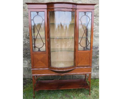 An Edwardian mahogany display cabinet, with barrel central glazed door, fitted with a shelf under, width 45ins, height 71ins,