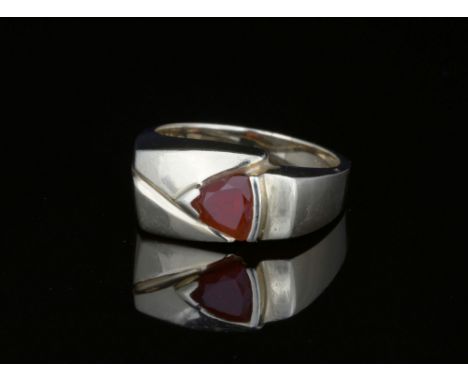 A 14ct yellow gold and red stone ringhallmarked 'USA TG 14K', the asymmetric ring set with a single trillion cut red-orange s