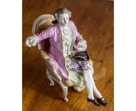 A Continental porcelain figure of a seated dandy, 19th century, possibly La Courtille, seated in powdered wig, pink coat over