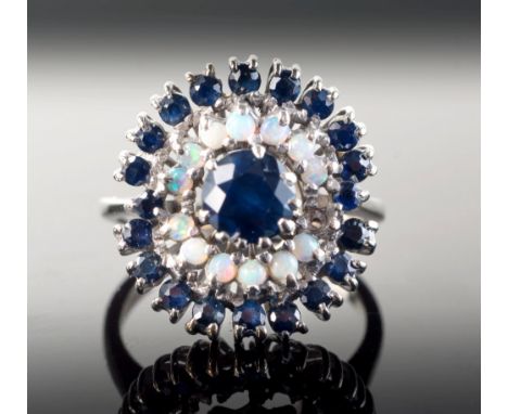 A vintage 18ct white gold, sapphire and opal cluster ringthe central round cut sapphire within double borders of small caboch