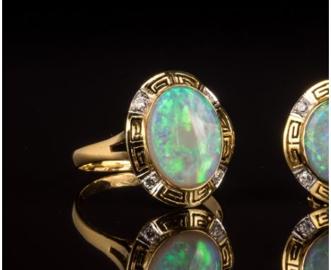 An 18ct yellow gold, opal and diamond cluster ringthe 14 x 11mm. opal within a pierced Greek key border set with four brillia