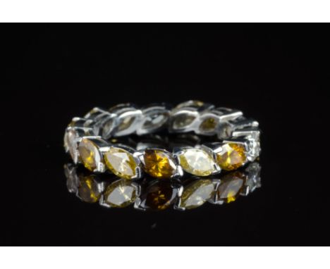 A fancy coloured diamond eternity ringthe unmarked, white metal ring, set at an angle with one white and fourteen fancy colou