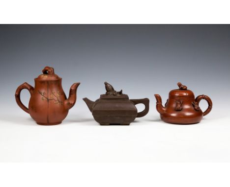 Three Chinese Yixing teapotsone of square cushion form on four small feet, lid with breaching fish finial, the smaller melon 