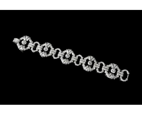 A magnificent Swedish Art Deco platinum and diamond braceletdesigned as a series of oval openwork fancy links, divided by sma