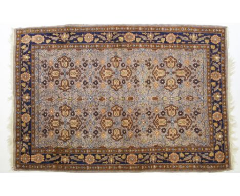 A Persian Hamadan rugthe pale grey-brown field with all over floral decoration and two rows of three stylised floral medallio
