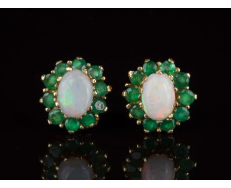 A pair of yellow gold, opal and emerald cluster earringsthe oval cabochon opals within a border of ten round cut emeralds. (2