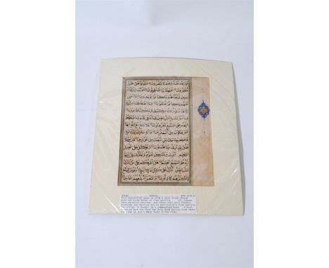A Persian manuscript page from the Koran, mid-16th century, fourteen lines of bold nashki script with a floral marginal devic