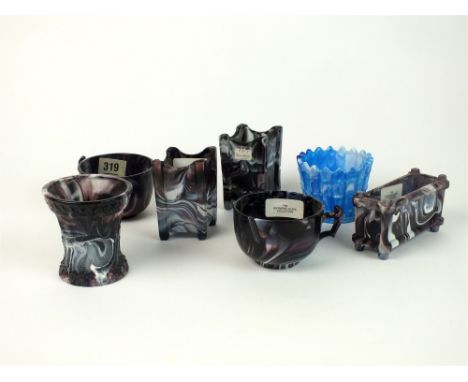 Seven pieces of Victorian purple and blue malachite 'slag' glass including a canted jar and cover on tripod feet, a pair of c