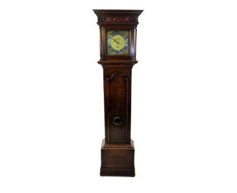 A George III cottage oak long case clock, the moulded cornice above a simple blind fret carved frieze and square glazed door 
