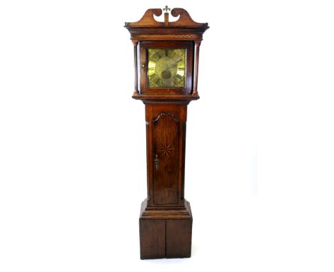 A George III oak and inlaid longcase clock, the broken scroll swan neck pediment centred by a brass fleur de lys motif on a c