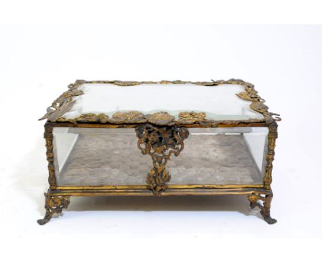 A French gilt metal mounted glass jewellery box, 19 th century, the rectangular cut glass cover cast with a broad border of l