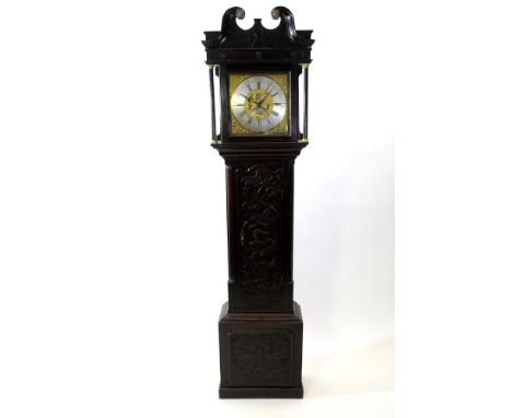 A George III oak cottage longcase clock, the later carved case with broken scroll swan neck pediment above a square glazed do