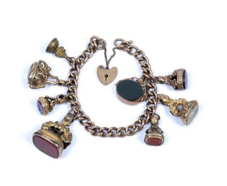 9ct yellow gold gate bracelet   with a collection of gold and yellow metal headstone seals, 84 grams approx.
