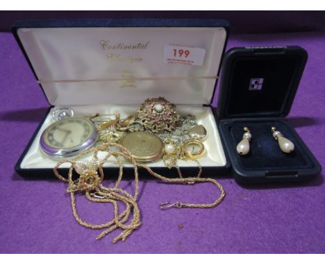 A small selection of costume jewellery including oversized locket, simulated pearl earrings, compass etc