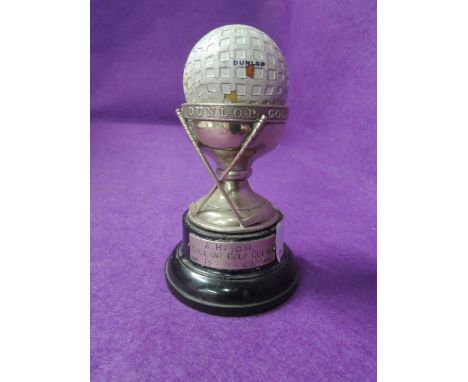 A small silver golf trophy having crossover clubs and marked Dunlop Golf Ball Hole in One Souvenir with vintage Dunlop golf b