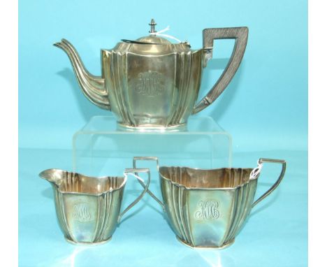 A three-piece bachelor's tea service of shaped oval form, comprising: teapot, cream jug and sugar bowl, monogrammed, London 1