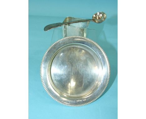 A plain circular three-footed dish with beaded rim, Birmingham 1966, an engine-turned napkin ring and a Georgian mustard spoo