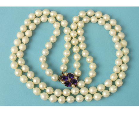 A necklace of two strings of uniform cultured pearls to 9ct gold amethyst and pearl cluster clasp.