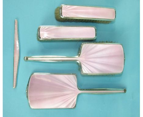 A mid-20th century pink-enamelled and silver dressing table set comprising: hair brush, two clothes brushes, a mirror and com