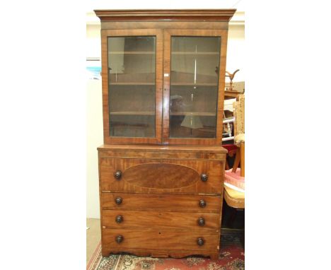 A Georgian mahogany secretaire bookcase, the pair of glazed doors above a fitted writing drawer and three drawers, on shorten