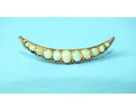 A small opal crescent brooch set eleven graduated opals in unmarked yellow metal mount, 41mm long, 2.5g, cased.