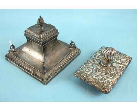 A late-Victorian loaded-silver inkwell of rectangular concave form, with gadrooned plinth and glass well, the finialled lid d