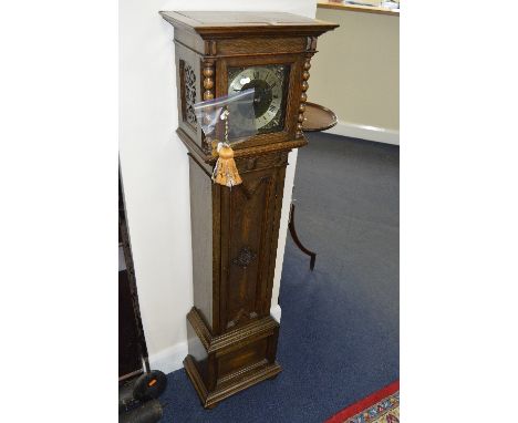 AN OAK CASED GRANDDAUGHTER CLOCK, with brass dial and Roman numerals, (winding key, pendulum and case key)