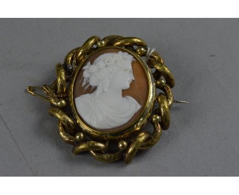 A VICTORIAN CAMEO BROOCH, carved shell cameo with a maiden in profile, with swivel hair locket to reverse, measuring approxim