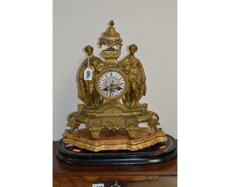 A LATE 19TH CENTURY GILT METAL MANTEL CLOCK, urn shaped finial with painted porcelain centre above the circular dial and two 