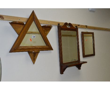 AN OAK FRAMED TRIANGULAR WALL MIRROR, with triple shelving, a mahogany wall mirror with a single shelf and another oak mirror