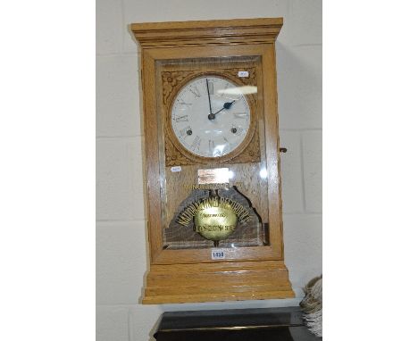A LIGHT OAK WALL CLOCK, manufactured by The National Time Recorder Co, London (winding keys and case key)