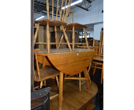 AN ERCOL PITCH PINE DROP LEAF DINING TABLE, and four chairs, pull out dining table and a coffee table (7)