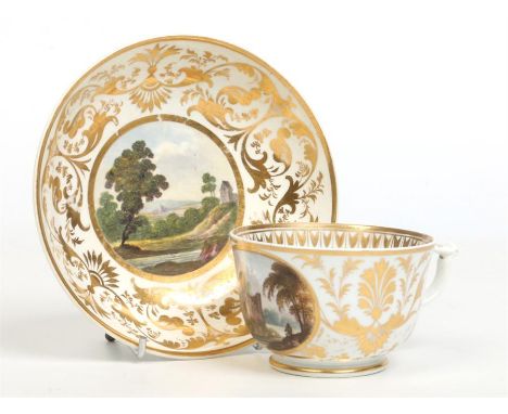 A 19th century Derby teacup and saucer with wishbone handle. With wide scrolling gilt borders and titled circular enameled pa
