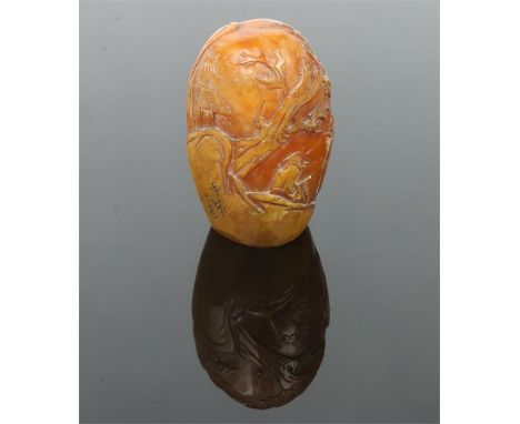 A Chinese carved soapstone boulder desk seal. Decorated in relief with a continuing landscape incorporating figures and trees